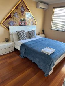 a bedroom with a large bed with a blue blanket at Radhe room in Perth