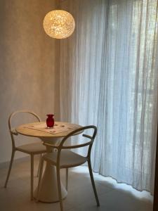 une table avec deux chaises et un lustre en verre dans l'établissement Casa Pellegrino, à Polignano a Mare