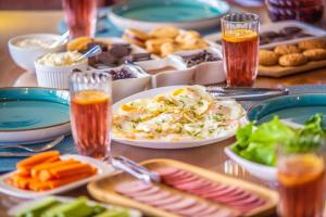 a table topped with plates of food and drinks at Chemodann Kazbegi in Stepantsminda