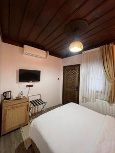 a bedroom with a bed and a flat screen tv at Albayrak Konağı Otel in Amasya