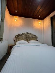 um quarto com uma cama branca e 2 almofadas em Albayrak Konağı Otel em Amásia