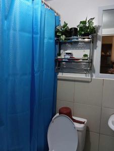 a bathroom with a blue shower curtain and a toilet at Casa Gabriel in Marilao in Marilao