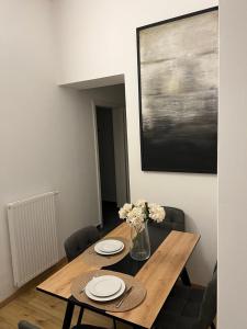 a dining room table with plates and flowers on it at Beatrix Home Vienna Luxury Stay in Vienna