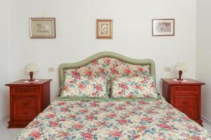 a bed with a floral bedspread and two night stands at Casa Mavi in Capri