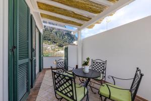 a patio with a table and chairs on a balcony at Casa Mavi in Capri
