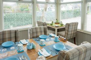 una sala da pranzo con tavolo e piatti blu di Bridgend House B&B a Drumnadrochit