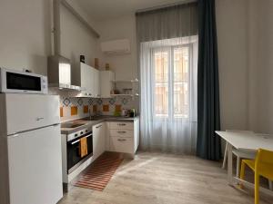 a kitchen with white appliances and a table and a window at Tabula Apartments in Olbia +26 photos