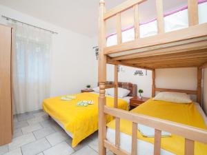 a bedroom with two bunk beds with yellow sheets at Apartments Ivo Bozinovic in Tivat