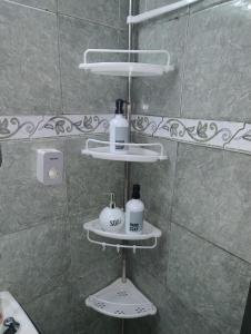 baño con ducha y 2 estanterías de jabón en S&B Apartamento, en Asunción