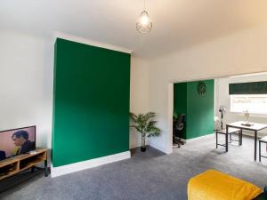 a living room with a green accent wall at Pass the Keys Fabulous location stylish home in Spennymoor