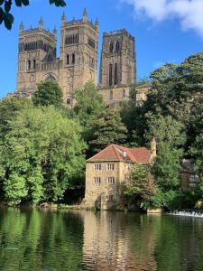 an old castle with two towers and a body of water at Pass the Keys Fabulous location stylish home in Spennymoor