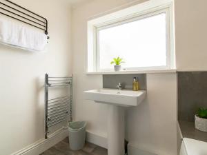 a white bathroom with a sink and a window at Pass the Keys Fabulous location stylish home in Spennymoor