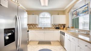 a kitchen with white cabinets and a refrigerator at 421 Cypress Bend condo in North Myrtle Beach