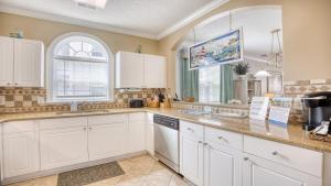 a kitchen with white cabinets and a sink at 421 Cypress Bend condo in North Myrtle Beach