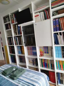 a room with a bed and several book shelves with books at Chambre dans maison avec salle de bain collective in Cluses