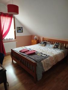 1 dormitorio con 1 cama grande y cortina roja en Chambre dans maison avec salle de bain collective en Cluses