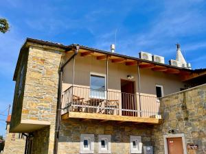 a stone house with a balcony on top of it at Santomas apartments in Šmarje