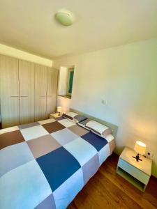 1 dormitorio con 1 cama grande con manta a cuadros en Santomas apartments, en Šmarje