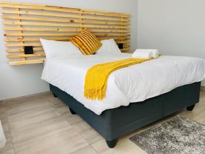 a bedroom with a large bed with a wooden headboard at Shafas Guest House in Rundu