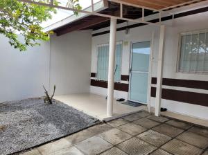 une porte ouverte d'une maison avec une terrasse couverte dans l'établissement CASA JARDIM PINHEIROS, à Maceió