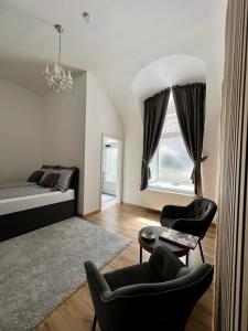 een slaapkamer met een bed en 2 stoelen en een tafel bij Beatrix Home Vienna Luxury Stay in Wenen