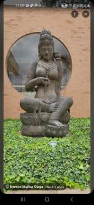 una estatua de una mujer sentada en el césped en Hotel Juaica, en Tenjo