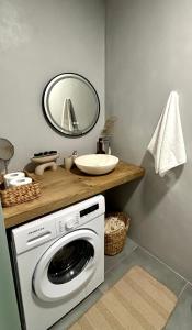 uma máquina de lavar roupa na casa de banho com um espelho em MYROVOLOS APARTMENTS em Quios