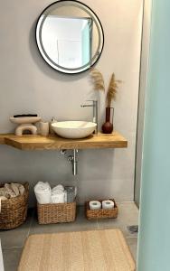 uma casa de banho com um lavatório e um espelho em MYROVOLOS APARTMENTS em Quios