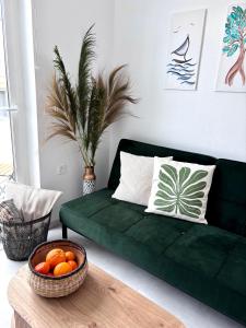 a green couch in a living room with a bowl of oranges at MYROVOLOS APARTMENTS in Chios