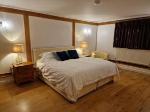 a bedroom with a bed with two lamps and a chair at The Barn New Forest Free Paddle boarding & free Zip wire. in Ringwood