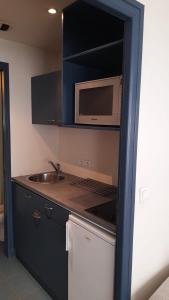 a kitchen with a sink and a microwave at triplex, centre-ville, terrasse in Nogent-sur-Marne +6 photos