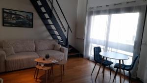 a living room with a couch and a table at triplex, centre-ville, terrasse in Nogent-sur-Marne