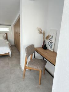 Schlafzimmer mit einem Schreibtisch, einem Stuhl und einem Bett in der Unterkunft MYROVOLOS APARTMENTS in Chios