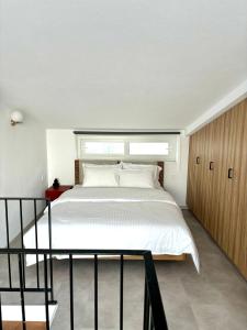 um quarto com uma cama grande e uma janela em MYROVOLOS APARTMENTS em Quios