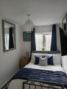 a bedroom with a large bed with blue and white pillows at Rowan House Rotherham in Rotherham