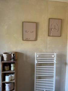 zwei Bilder an der Wand einer Küche mit einem Kühlschrank in der Unterkunft Le coin des hirondelles in Asfeld