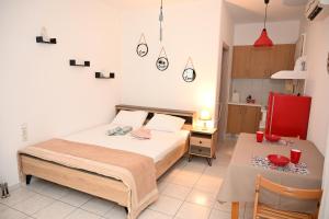 a small bedroom with a bed and a table at Aurora Studio Apt for Couples & Friends in Heraklio Town