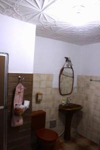 a bathroom with a sink and a toilet and a mirror at Casa da Alvenaria- Praia de Mauá in Rio de Janeiro +12 photos