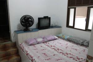 a bedroom with a bed with a tv on top at Casa da Alvenaria- Praia de Mauá in Rio de Janeiro