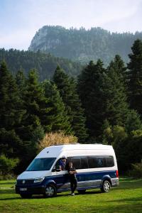 a man standing next to a van in a field at Reunion in Greece Campervan in Drafí