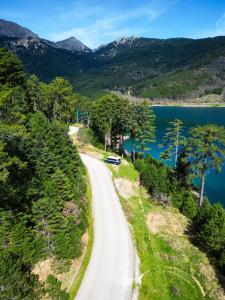 a road next to a lake with a car on it at Reunion in Greece Campervan in Drafí