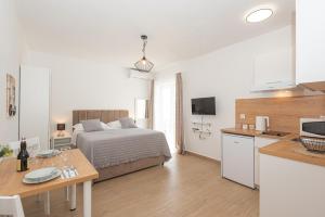 a bedroom with a bed and a kitchen with a table at Apartments Lovrić in Vodice