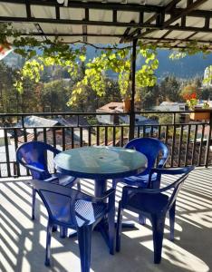 einen Tisch und Stühle auf einer Terrasse mit Aussicht in der Unterkunft Guesthouse Saba in Bordschomi