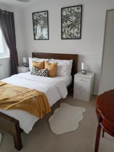 a bedroom with two beds with pillows and a mirror at Rowan House Rotherham in Rotherham