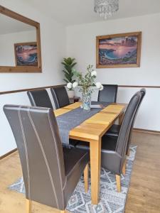 a dining room with a wooden table and chairs at Rowan House Rotherham in Rotherham