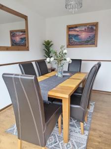 a dining room with a wooden table and chairs at Rowan House Rotherham in Rotherham +12 photos