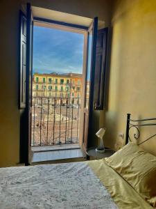 a bedroom with a bed and a window with a view at La Casetta In Piazza in Sulmona