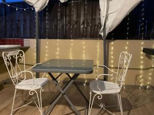 een tafel en stoelen in een kamer met verlichting bij CASA VACANZE ETNA COUNTRY in Tremestieri Etneo