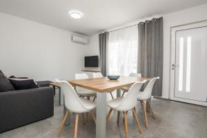 a dining room with a wooden table and white chairs at Ferienwohnung mit Terrasse in Vir