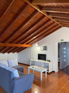 a living room with a blue couch and a table at Santo Cristo Loft in Lajes das Flores